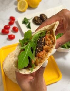 Egyptian ful (fava beans), tameya, eggs, arugula salad, tomatoes, lemon