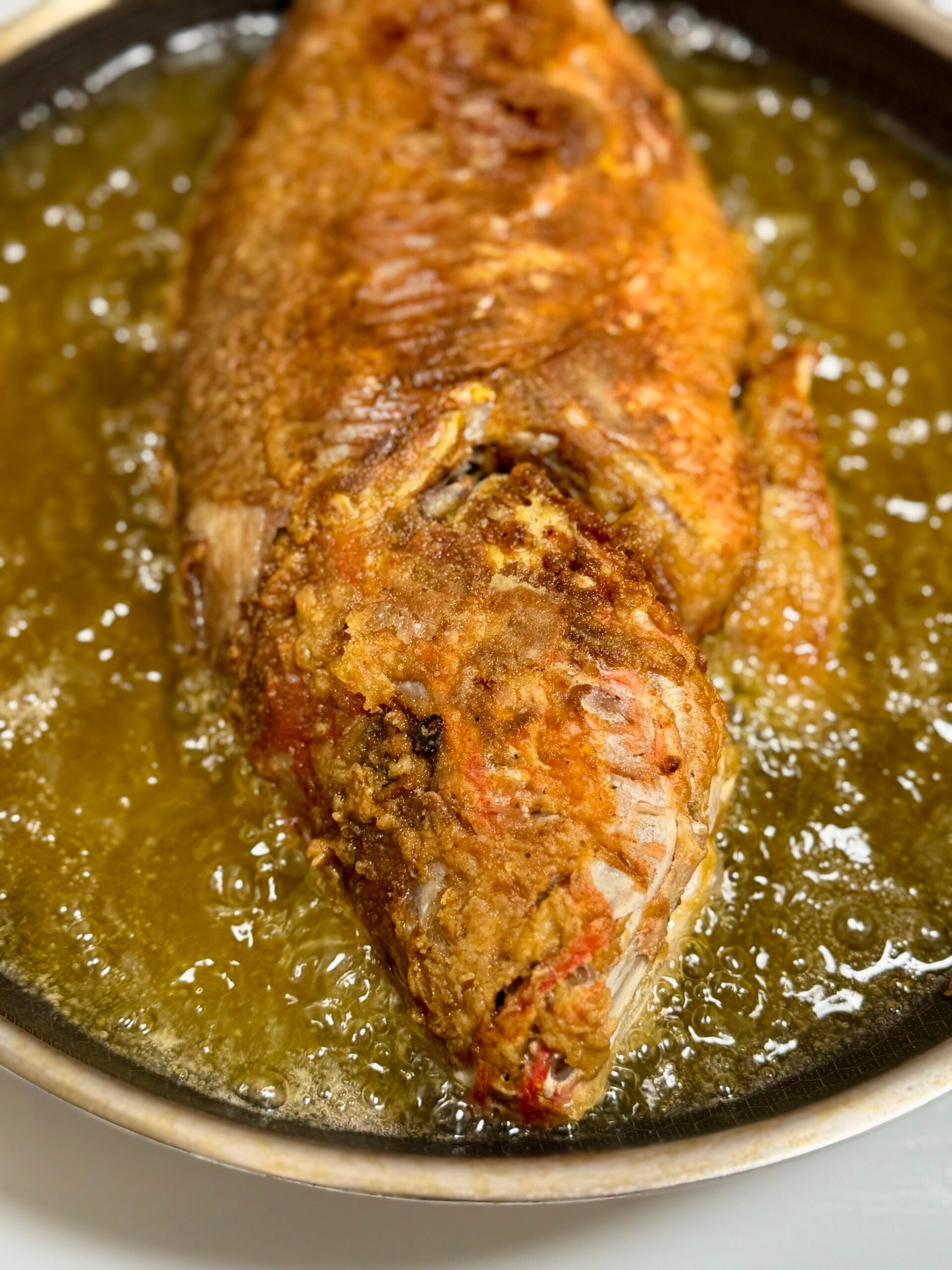 Jamaican Red Snapper frying in pan